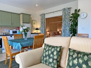 ein Wohnzimmer und eine Küche mit einem Sofa und einem Tisch in der Unterkunft Apartment 432 - Clifden in Clifden