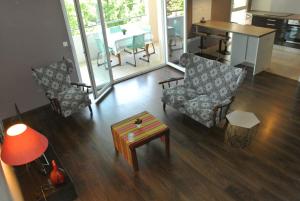 ein Wohnzimmer mit 2 Stühlen und einem Tisch in der Unterkunft beau t3 en duplex, calme et paisible in Bayonne