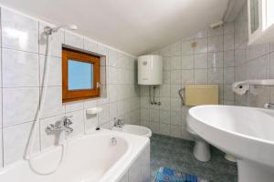 a bathroom with a tub and a sink and a toilet at Apartment Nada in Mundanije +44 photos