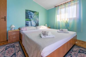 a blue bedroom with two beds and a window at Apartment Nada in Mundanije