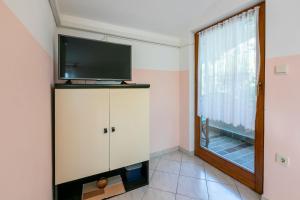 a living room with a tv on top of a cabinet at Apartment Nada in Mundanije