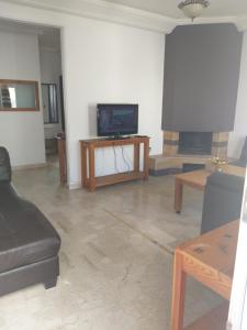 a living room with a tv and a fireplace at Bel appartement meublé B 16 in El Jadida