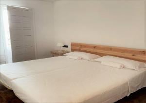 a bedroom with a large white bed with two pillows at Hotel los Tilos in Beteta