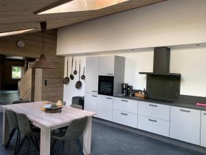 a kitchen with white cabinets and a wooden table at Atelier Onder de Notenboom in Appeltern