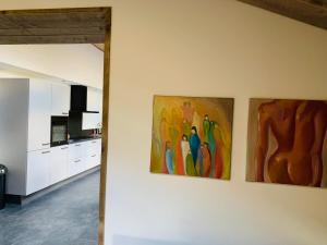 a kitchen with three paintings on the wall at Atelier Onder de Notenboom in Appeltern