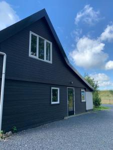 a black house with two windows on it at Atelier Onder de Notenboom in Appeltern