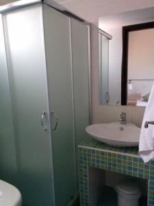 a bathroom with a sink and a toilet and a mirror at Attalos Apartments in Agia Pelagia