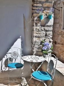 2 Stühle und ein Tisch auf der Terrasse in der Unterkunft House Stone house Mia casa in Stari Grad