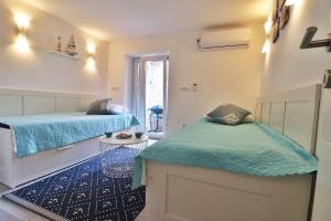 a room with two beds and a table in it at House Stone house Mia casa in Stari Grad