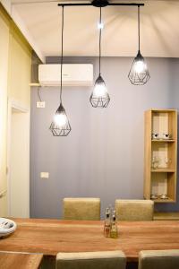 een eetkamer met een tafel en 3 verlichting bij DelMar Apartments in Golem