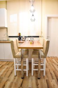 een keuken met een houten tafel en stoelen bij DelMar Apartments in Golem