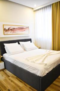 een slaapkamer met een groot bed voor een raam bij DelMar Apartments in Golem