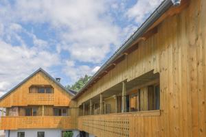a wooden building with a deck on the side of it at Apartments Mulej in Bled