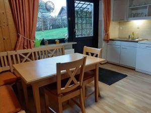 a kitchen with a wooden table and a table and chairs at Ferienwohnung am Hasenweg in Ruhstorf