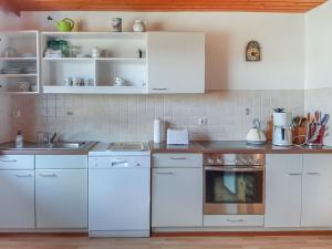 a kitchen with white cabinets and a stove top oven at Ferienwohnung am Hasenweg in Ruhstorf