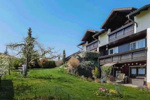 una casa con césped junto a un edificio en Ferienwohnung am Hasenweg, en Ruhstorf