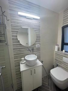 a bathroom with a sink and a toilet and a mirror at מענה שמחה רוממה ירושלים דירת אירוח in Jerusalem