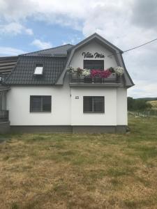 ein weißes Haus mit zwei Fenstern mit Blumen drauf in der Unterkunft Villa Mia in Levoča