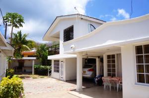 una casa blanca con un coche aparcado en la entrada en Posada Vasquez Oviedo, en San Andrés