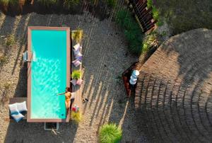 una vista sul soffitto di una piscina con una persona che lo sta accanto di Is Cheas wine farm boutique hotel a San Vero Milis