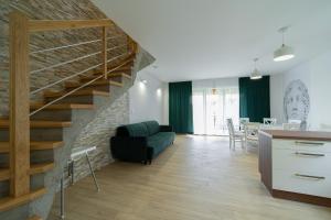 uma sala de estar com uma escada e uma sala de jantar em Villa Arkadia PORTUS em Dziwnów