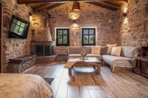 a living room with a couch and a fireplace at Karyoupolis Lounge Cave House in Gythio