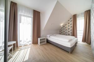 a bedroom with a bed and a large window at Villa Arkadia PORTUS in Dziwnów