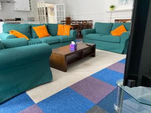 a living room with two blue couches and a coffee table at Gazeley Manor House - Central Huntingdon in Huntingdon