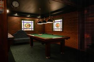 a room with a pool table and stained glass windows at ApartHotel Hubertus in Białystok