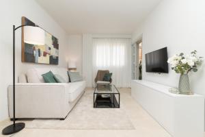 a white living room with a white couch and a tv at iloftmalaga Martínez Maldonado in Málaga