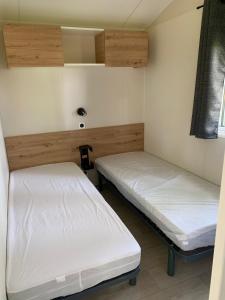 Duas camas num quarto com paredes brancas em L'auberge du moulin des prés em Maroilles