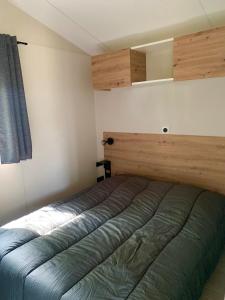 - une chambre avec un lit et une tête de lit en bois dans l'établissement L'auberge du moulin des prés, à Maroilles