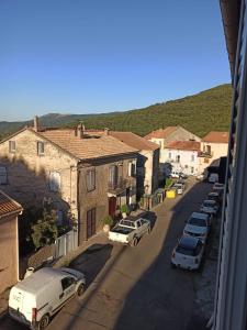 a view of a street with cars parked in a town at Chez Laurette Murato in Murato