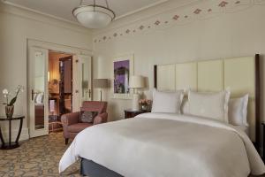 a bedroom with a large white bed and a chair at Four Seasons Hotel Gresham Palace Budapest in Budapest +67 photos