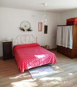 um quarto com uma cama com uma colcha de bolinhas vermelhas em Alojamiento Rural La Noria em Cortegana
