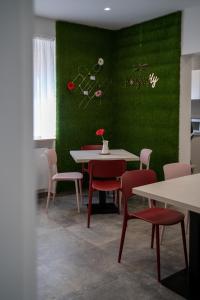 un comedor con una pared verde, mesas y sillas en Dragonfly affittacamere, en Motta Montecorvino