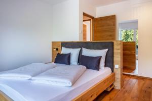 a large bed with white sheets and blue pillows at Luisl Hof - Apartment Vinum in Cornaiano
