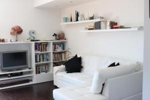 a living room with a white couch and a tv at Casa di Princi in Brunate