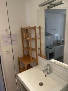 a small kitchen with a sink and a mirror at Loft de la plage Concurrence in La Rochelle +2 photos