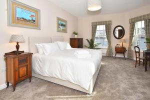 a bedroom with a white bed and a table and chairs at The Sutherland Arms in Stoke on Trent