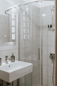 y baño blanco con lavabo y ducha. en Panoramic Vlachos en Gjirokastër