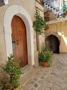 einen Eingang zu einem Gebäude mit einer Holztür in der Unterkunft Casa Petra in Castellabate