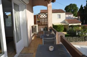 a balcony with a table and chairs on a house at LES OISEAUX in Saint-Cyr-sur-Mer
