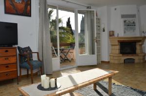 a living room with a table and a fireplace at LES OISEAUX in Saint-Cyr-sur-Mer