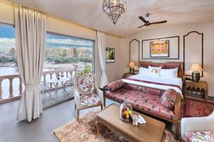 BeraにあるWelcomHeritage Cheetahgarh Resort & Spaのベッドとバルコニー付きのホテルルーム