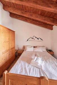 a bedroom with a bed with mountains on the wall at Hotel Bed & Bike Ledro in Molina di Ledro