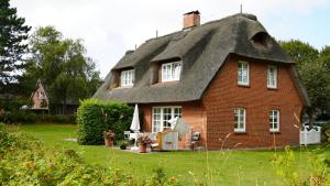 a house with a thatched roof in a yard at Haus Bornholm Whg 04 in Nieblum