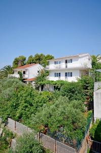 een wit gebouw bovenop een heuvel met bomen bij Apartments BJ in Marina