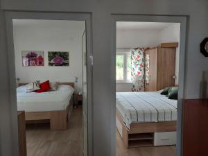 a bedroom with two beds and a mirror at Beach House in Betina