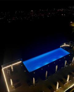 una piscina notturna con sedie intorno di Hotel Bellavista a Porto San Giorgio